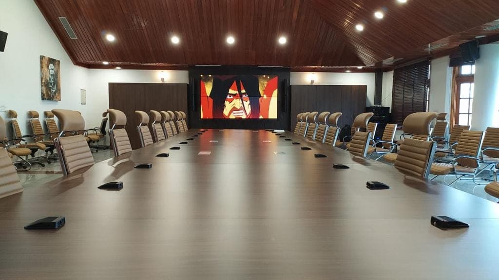 Conference room at the Chief Minister's Residential Complex, Kohima — Samsung fine-bezel 2×2 video wall above the boundary-microphone conference table.