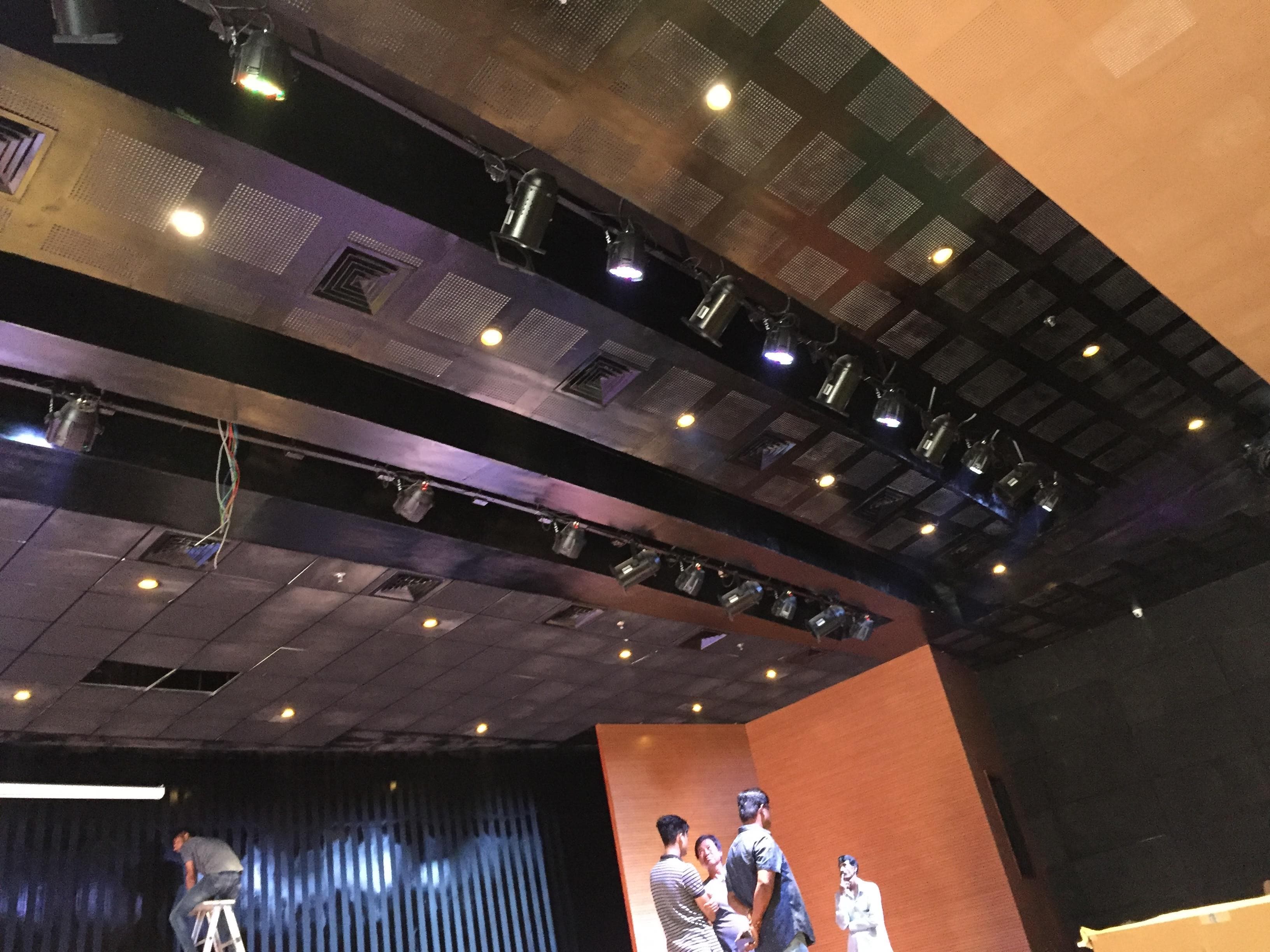 Multi-Purpose Hall Itanagar — stage lighting truss with profile, fresnel, planoconvex and PAR fixtures threading the architectural ceiling