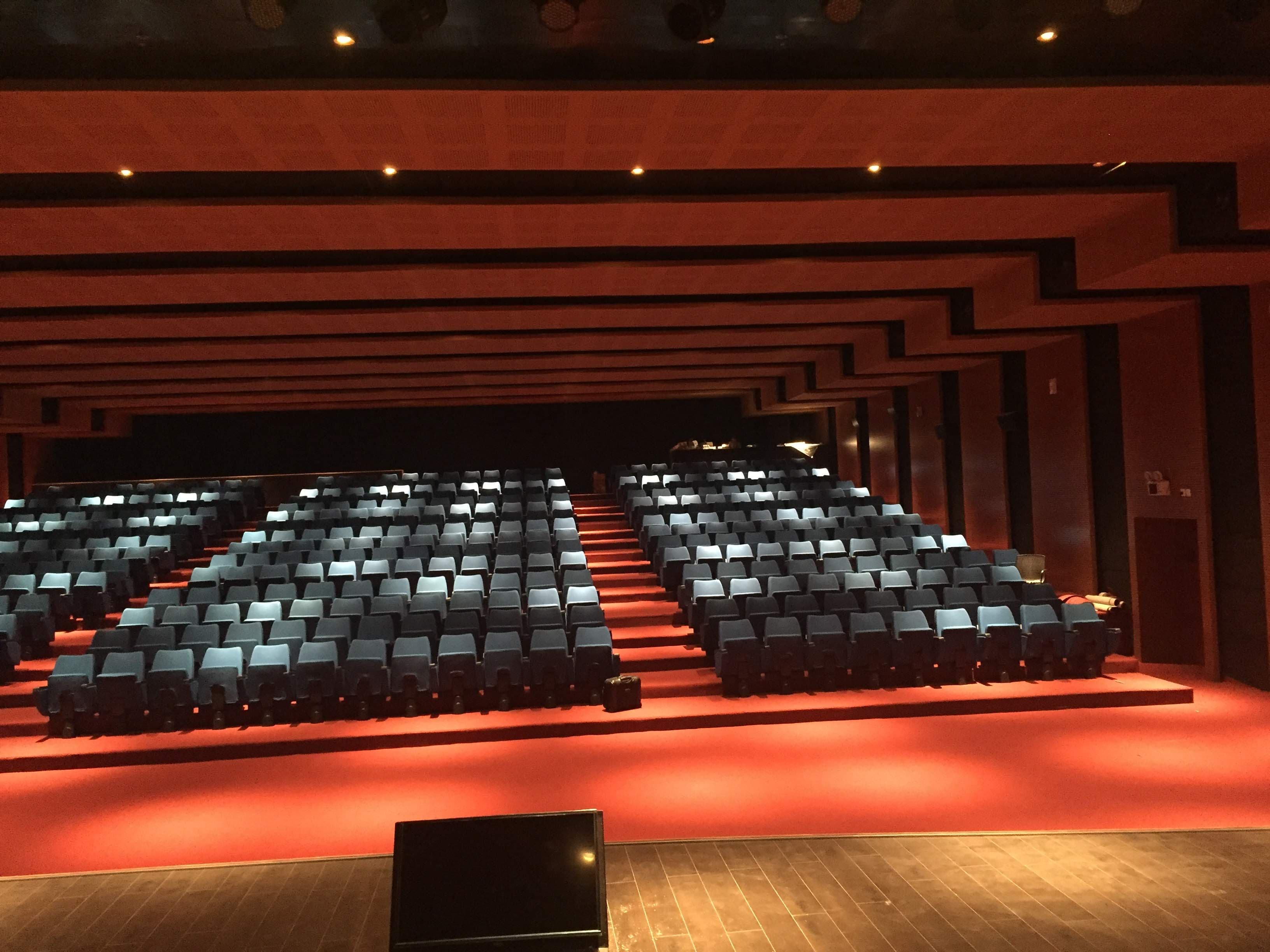 Multi-Purpose Hall Itanagar — audience plane viewed from the stage with tiered blue seats, operator booth at rear and Dias View monitor