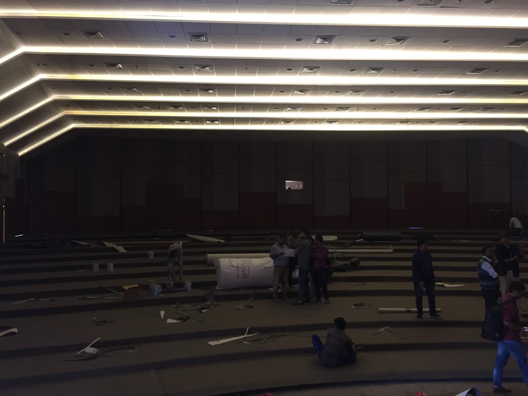 Namsai Multipurpose Cultural Hall stepped cove ceiling lighting over the raked auditorium floor, during installation.