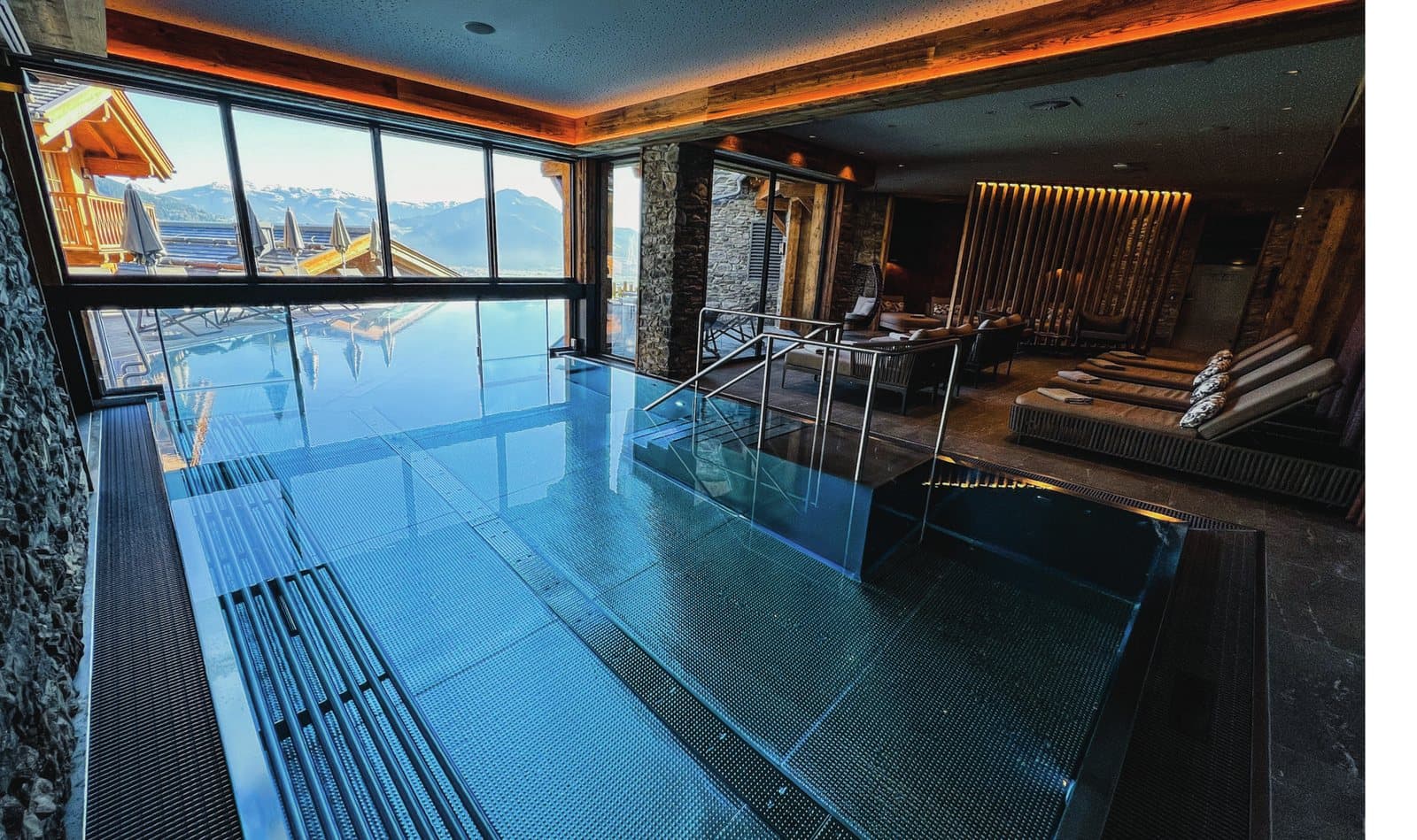 A premium hotel spa and infinity pool with floor-to-ceiling mountain views — the kind of design-led hospitality and wellness interior K-array and KGEAR systems are specified for