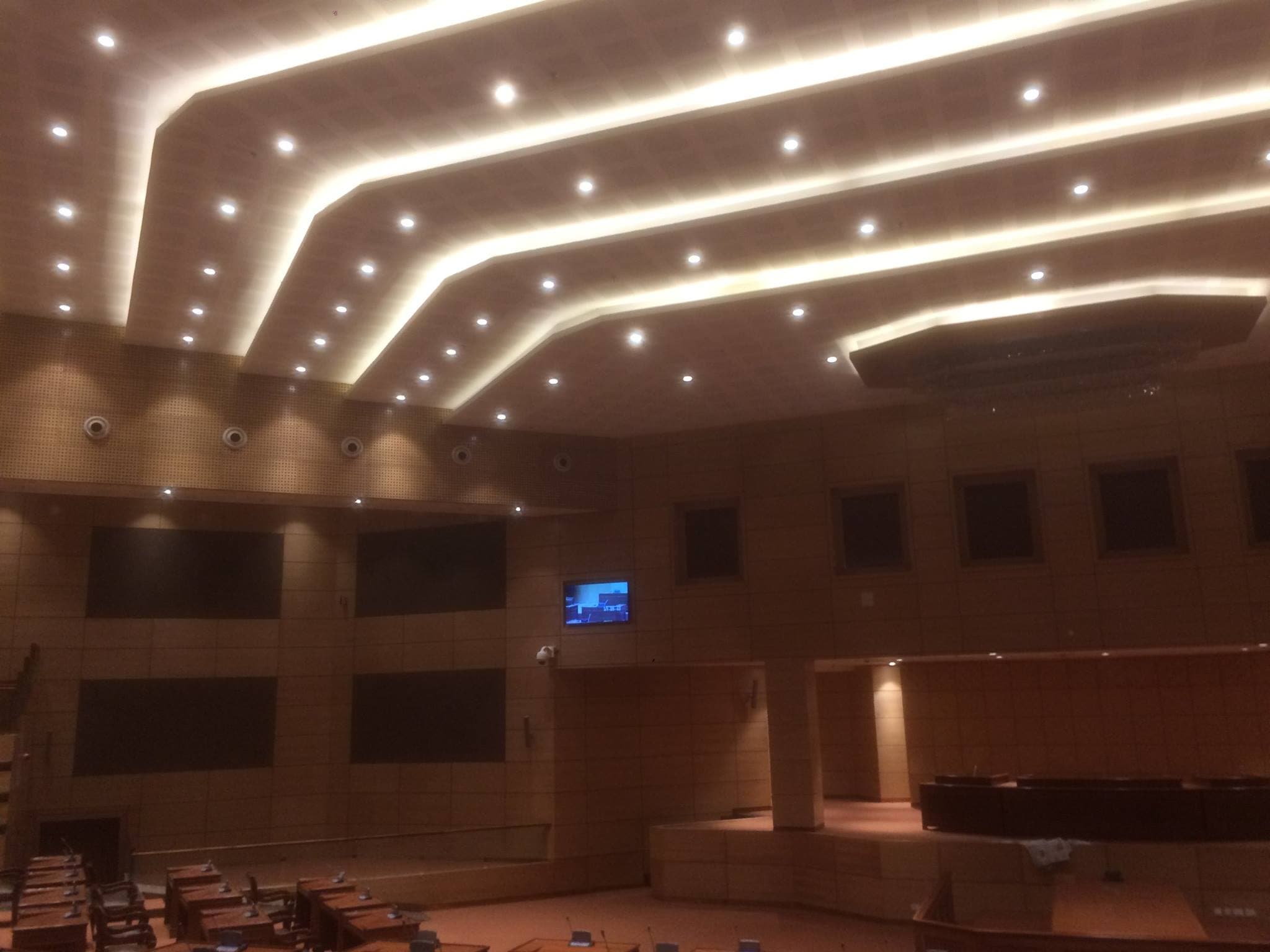 Assembly chamber with calm even task lighting and architectural cove glow during interpretation routing.