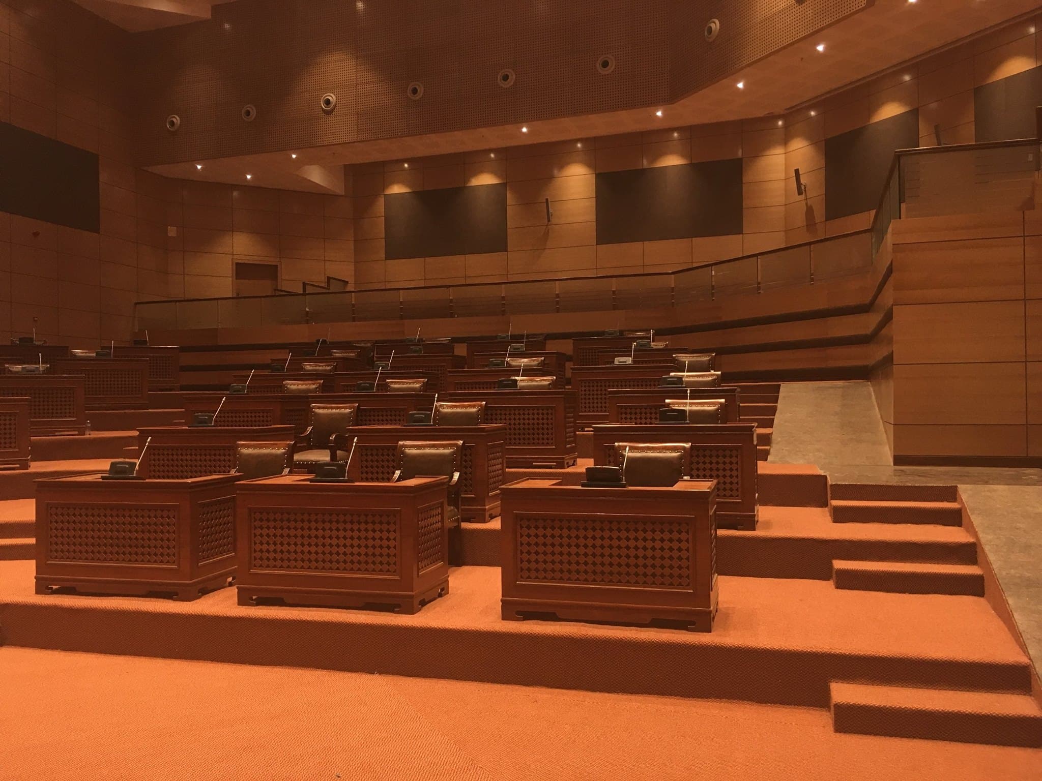 Assembly chamber after hours — emergency pathway lighting only, all systems powered down.