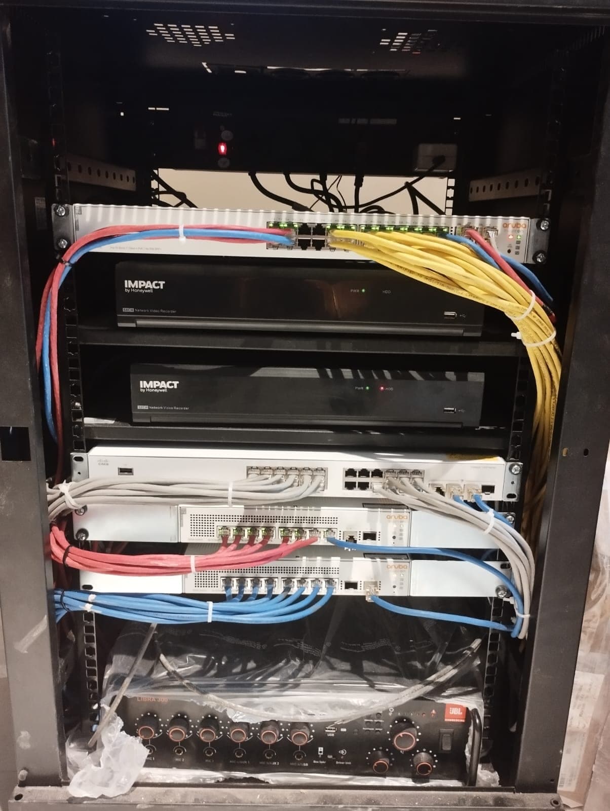 Taraghar head-end rack with Honeywell IMPACT NVRs, HP Aruba PoE switch and JBL Libra 300 amplifier