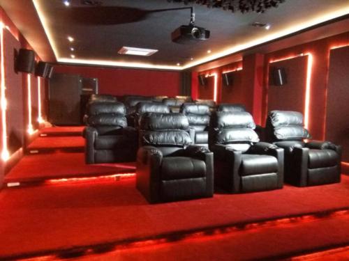 Home theatre Imphal — black leather recliners, red LED perimeter lighting