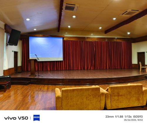 Niathu Resort event hall Dimapur — red velvet curtains, projection screen, wooden podium