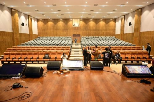 Town Hall auditorium Dimapur — orange seats, stage monitors